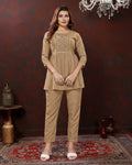 Woman wearing a beige outfit in a room with decorative elements.