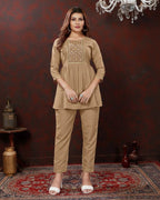 Woman wearing a beige outfit in a room with decorative elements.
