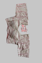 A pink and silver embellished blouse top with matching pink tie details, laid flat on a gray fabric background.
