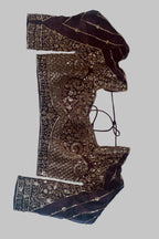 An embroidered dark brown and black blouse with intricate gold sequin and mirror work, laid flat on a light blue fabric background.