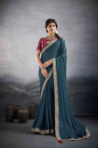 A woman models a teal blue saree with a red and gold embroidered blouse against a textured gray studio backdrop. The brand name 'suma MEHAR' is visible in the top right corner.