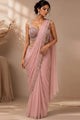Three views of a woman modeling a sleeveless sari dress in soft dusty pink and light blue shades, shown in an elegant indoor setting with warm lighting and architectural details.