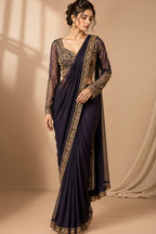 Three views of a woman modeling a traditional Indian saree in a studio setting. The saree has a deep navy blue body with a gold embroidered border, paired with a matching navy blue lace blouse, and is shown in three colorways: navy blue, dark navy blue, and deep purple.