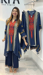 Woman wearing a blue and red traditional outfit with matching dupatta in a store setting.