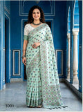 A woman modeling a mint green saree with a white printed blouse in a blue architectural corridor, shown in a side-by-side collage format with the number 1001 in the lower left corner.