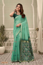 Woman in a green saree with a decorative background and 'Gobuni' branding.