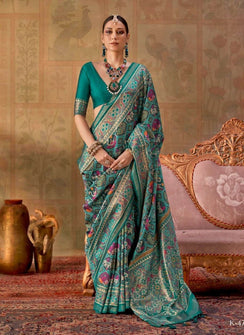 Woman in a traditional saree with intricate patterns, sitting on a decorative chair with 'Kreshya' branding.