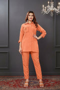 Woman wearing an orange outfit with a dark background