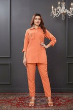 Woman wearing an orange outfit with a dark background