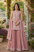 Woman in a pink traditional outfit with floral decorations in the background