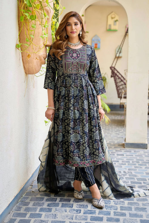 Woman wearing a patterned dress standing in a decorative outdoor setting with 'mystic 9' branding.