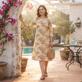 Woman wearing beige floral printed cotton A-line kurti with three-quarter sleeves and front button detailing