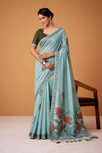 Woman wearing a light blue saree with floral patterns on a beige background