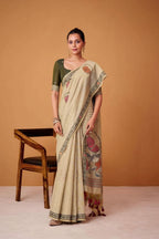 Woman wearing a beige saree with floral patterns on a brown background, featuring the brand 'Rajpath'.