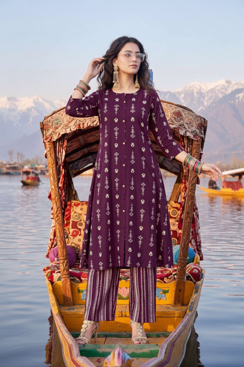 Woman in a purple traditional outfit on a boat with mountains in the background