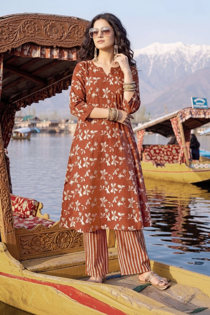 Woman in a traditional outfit on a boat with mountains in the background