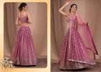 A woman modeling a pink embellished lehenga choli set with a dupatta, shown in front and back views against a beige draped backdrop.